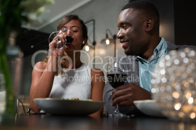Happy couple having red wine while dining