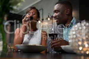 Happy couple having red wine while dining