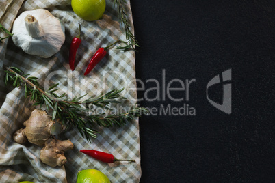 Garlic, red chili pepper, sweet lime, ginger and rosemary on table cloth