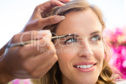 Cropped hand of beautician applying makeup to bride