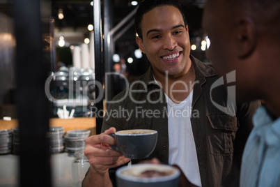 Happy man interacting while having coffee