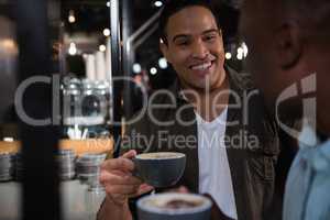 Happy man interacting while having coffee