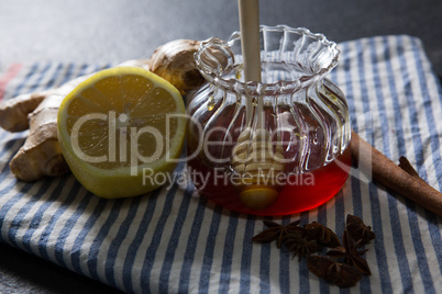 Ginger, star anise, cinnamon, lemon and honey in jar on textile