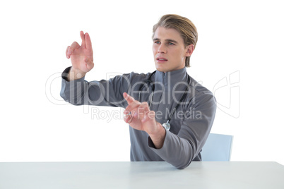 Male doctor touching imaginary interface screen while sitting at table
