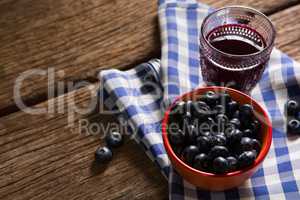 Bowl of blueberries and juice on wooden table