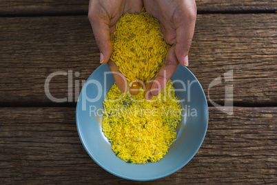 Hands pouring rice in a bowl