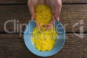 Hands pouring rice in a bowl