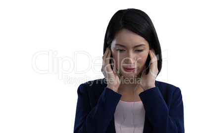 Businesswoman listening music on headphones