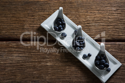 Blueberries in spoon arranged on tray