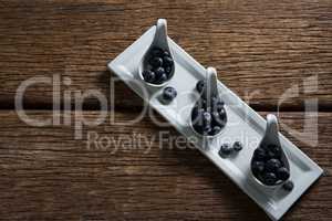 Blueberries in spoon arranged on tray