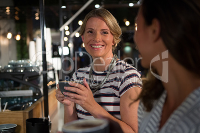 Happy woman interacting while having coffee