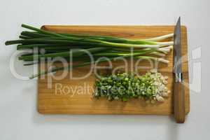 Chopped scallions with knife on chopping board