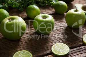 Green apple and sliced lemon arranged on wooden table