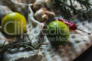 Sweet limes with rosemary and spices on table cloth