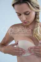 Close up of woman checking lumps while examining breast
