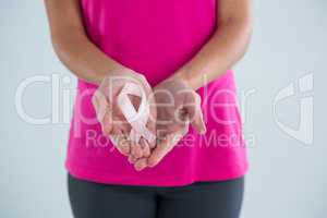 Mid section of woman with pink ribbon