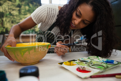 Beautiful woman painting bowl