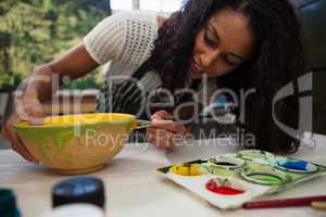 Beautiful woman painting bowl