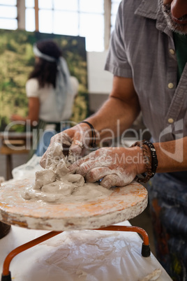 Mid section of man molding clay