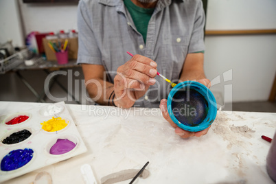 Mid section of man painting bowl