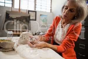 Attentive senior woman molding clay