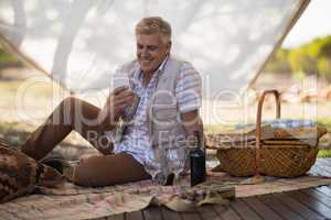 Happy man using mobile phone in cottage