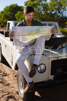 Full length of man reading map on off road vehicle