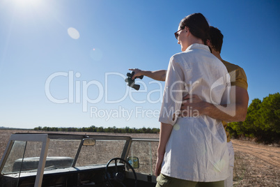 Man with woman pointing while standing on off road vehicle