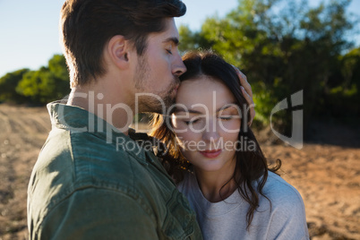 Man kissing woman on landscape