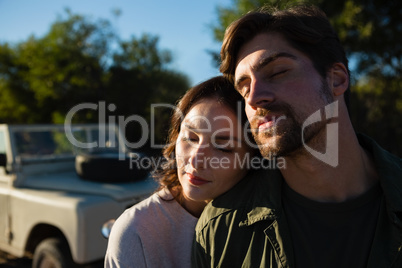 Couple with eyes closed by vehicle