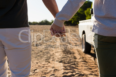 Mid section of couple holding hands