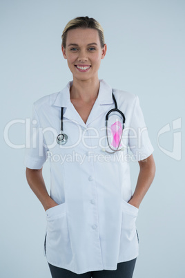 Portrait of happy female doctor with Breast Cancer Awareness ribbon