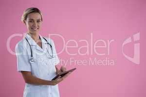 Portrait of smiling female doctor using tablet