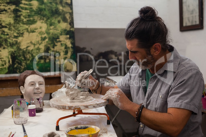 Attentive man molding clay