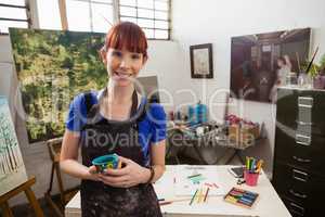 Portrait of beautiful woman holding painted bowl