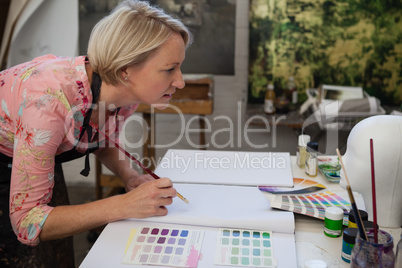 Woman painting in drawing book