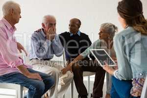 Senior friends consoling man during discussion