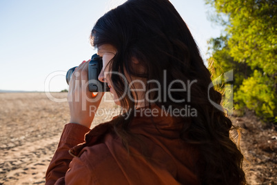 Woman photographing from camera on field