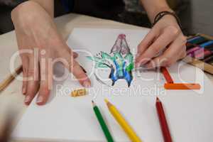 Close-up of woman sketching in drawing book