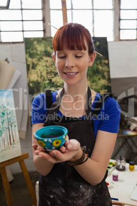 Beautiful woman looking at painted bowl