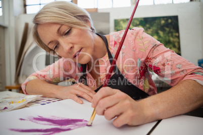 Woman painting in drawing book