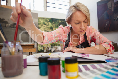 Woman selecting a paintbrush
