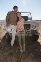 Full length of couple by off road vehicle