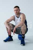 Confident player sitting on basketball