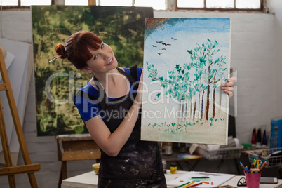 Portrait of beautiful woman holding her painting