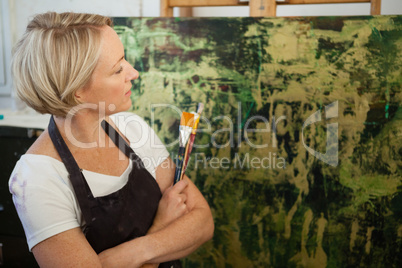 Thoughtful woman looking at her painting