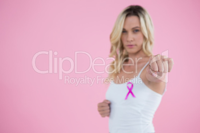 Portrait of young woman with Breast Cancer Awareness ribbon punching