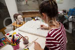 Woman sketching on canvas in drawing class