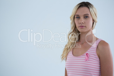 Portrait of young female in tank top with pink ribbon
