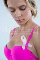 Young woman in pink bra with Breast Cancer Awareness ribbon